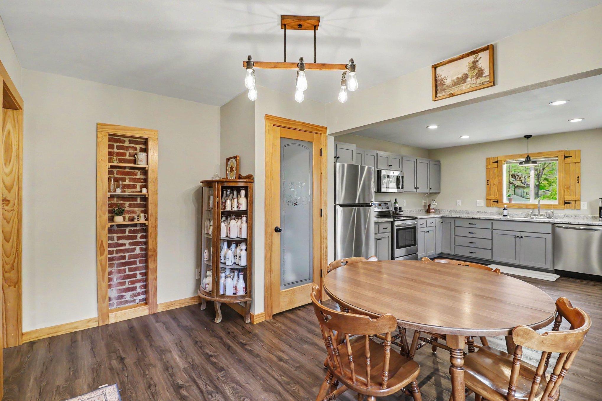Full kitchen and dining space with modern pendant lights and stainless appliances — entry-level MN home