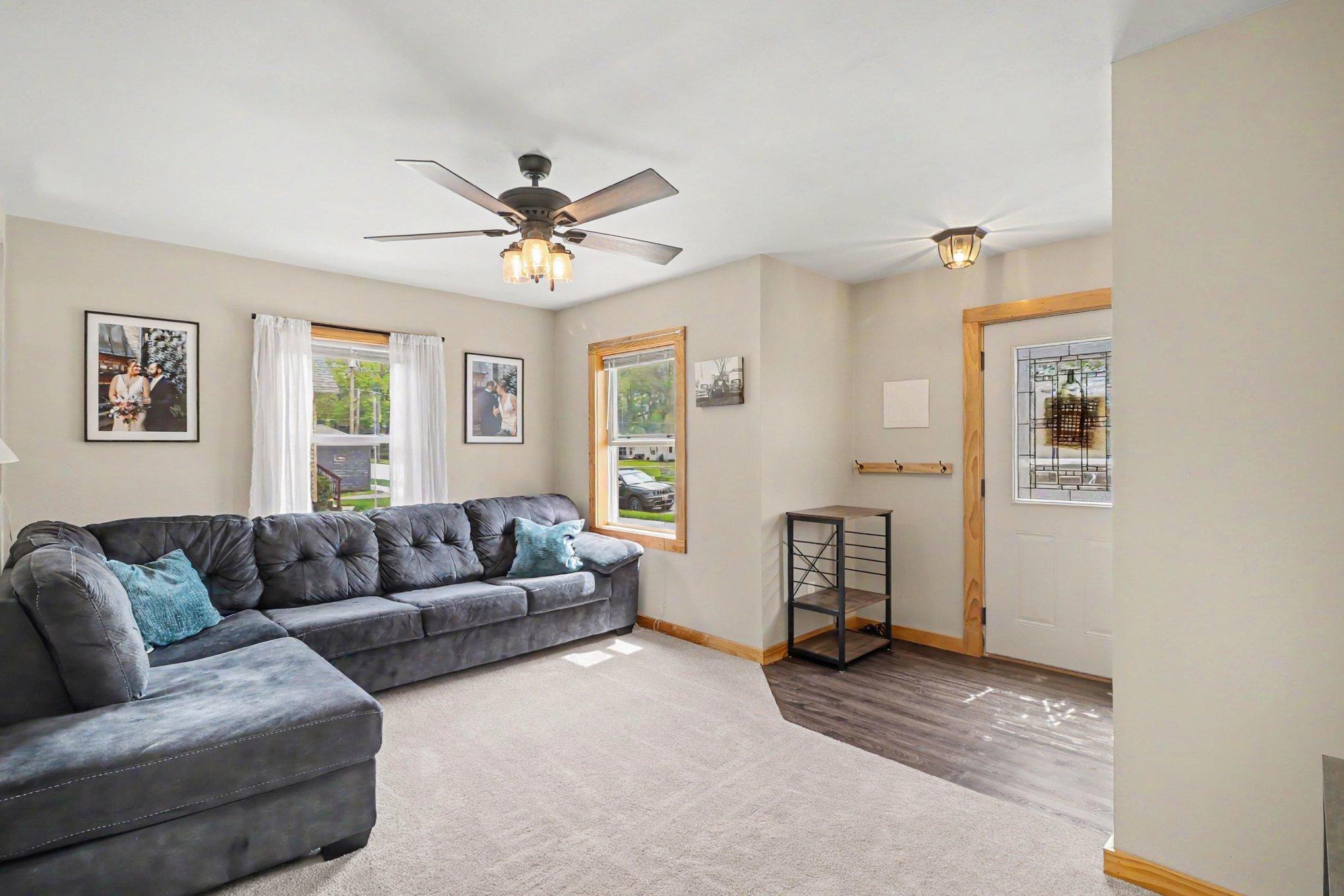 Main level living room with LVP flooring, ceiling fan, and natural light — Montgomery MN home for sale