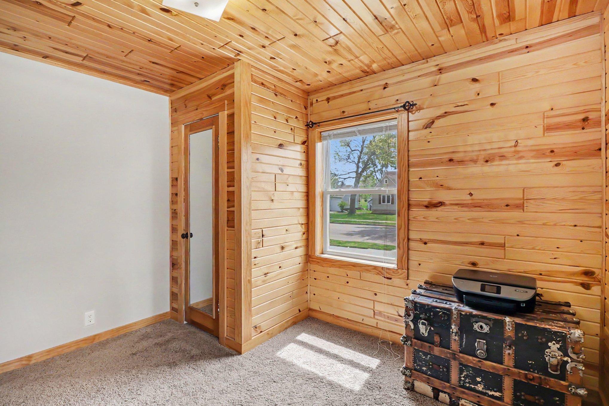 Main floor bedroom with tongue-and-groove pine walls and ceiling — Montgomery MN homes for sale