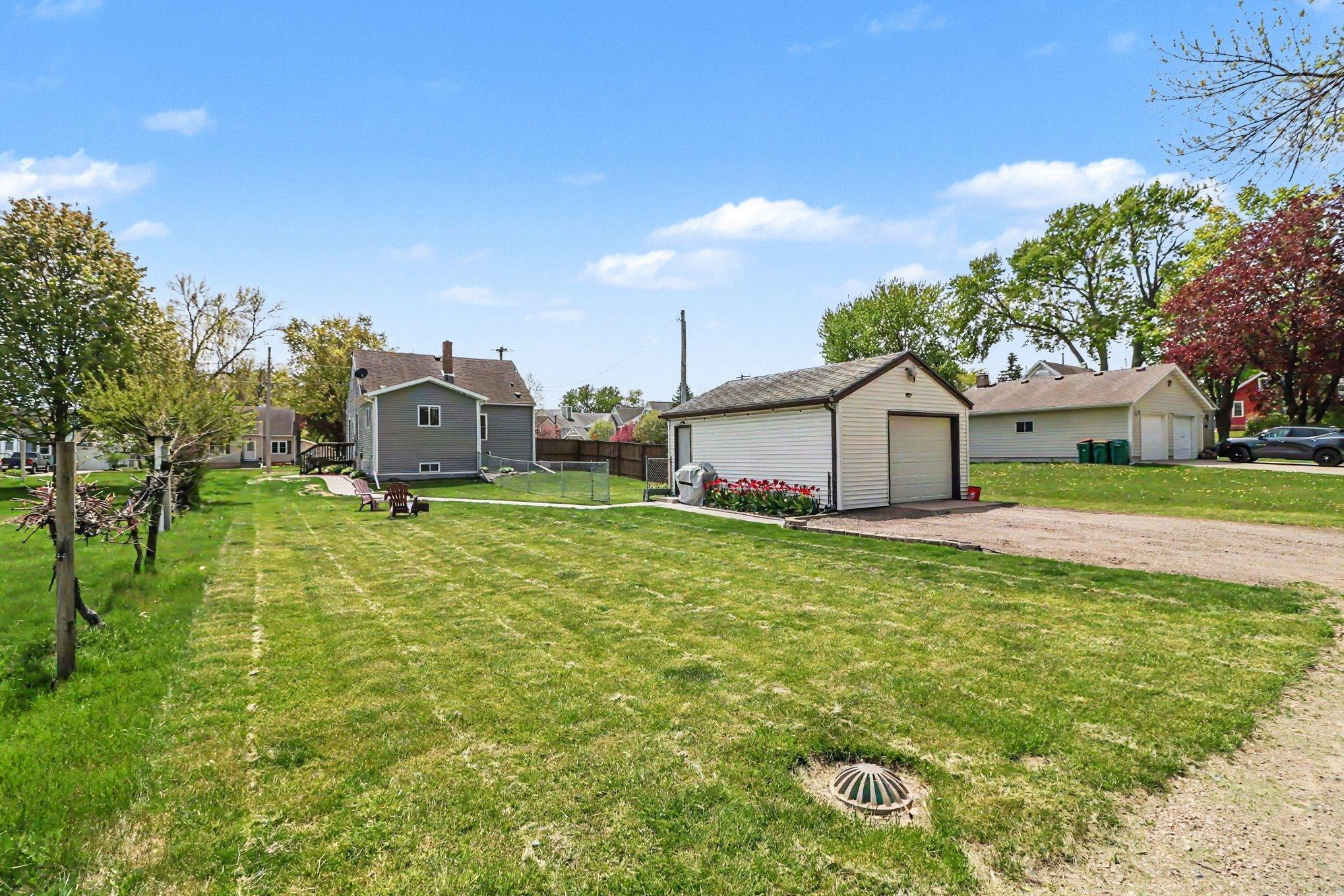 Large backyard with detached 1-car garage, fenced area, and open green space — Montgomery MN
