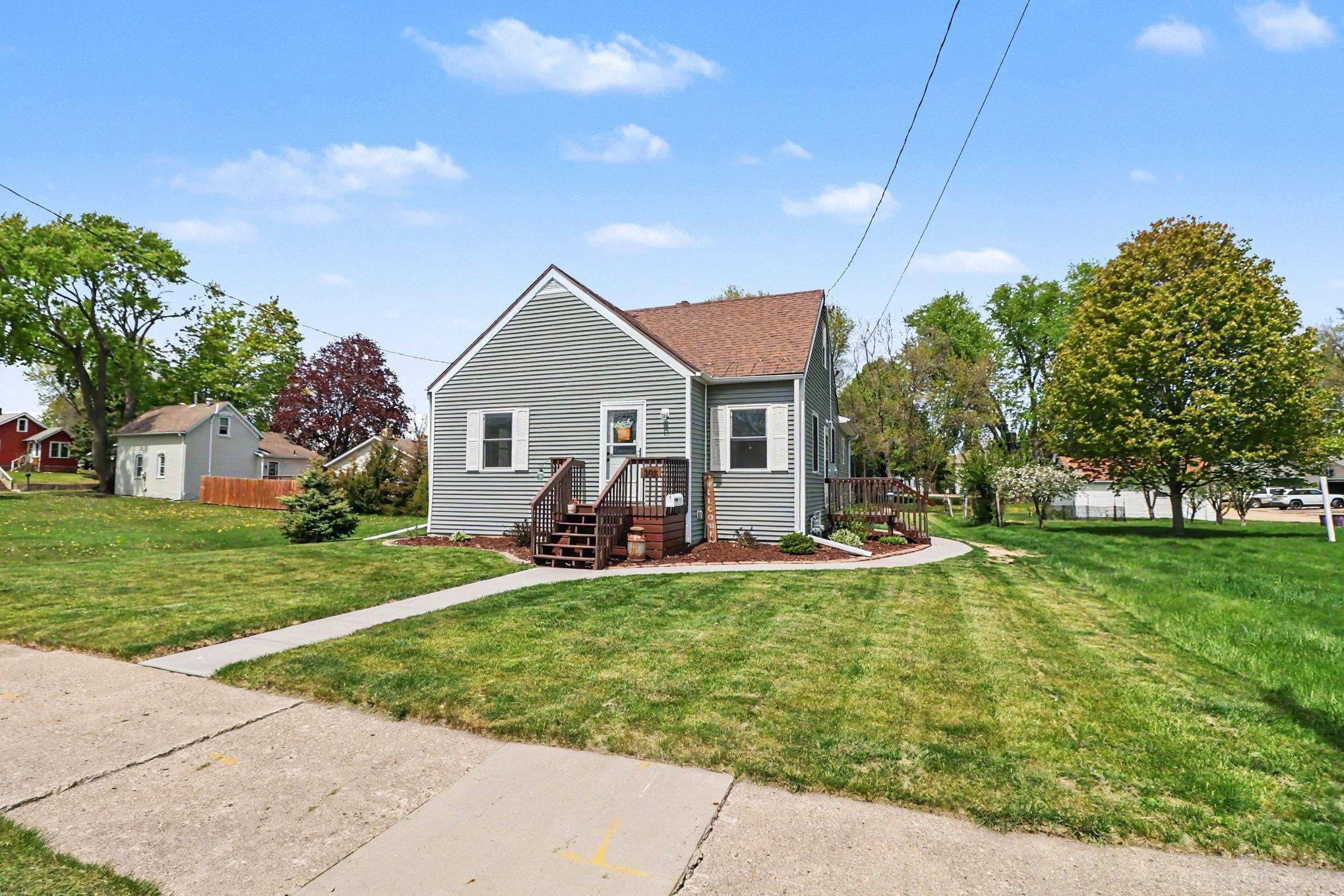 Curb view of 305 Oak Ave SE Montgomery MN — mature trees, 2024 landscaping