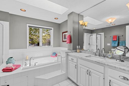 The owners bathroom suite with skylight, granite countertops, tiled floor, soaking tub and shower.