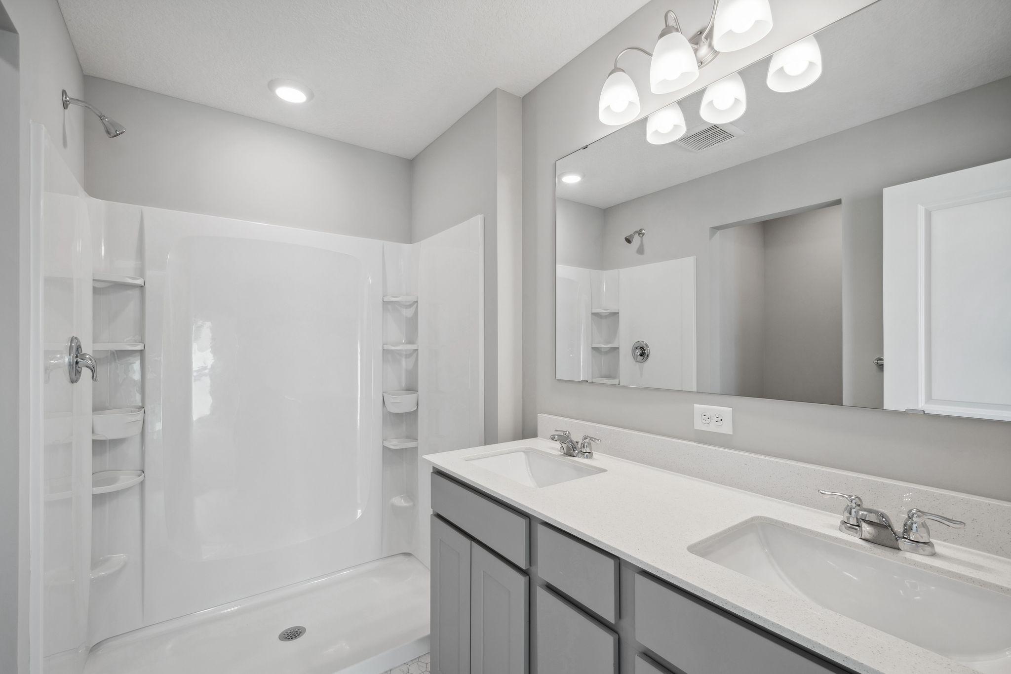 En suite finishes off the primary bedroom with dual vanities