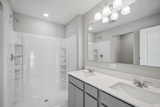 En suite finishes off the primary bedroom with dual vanities