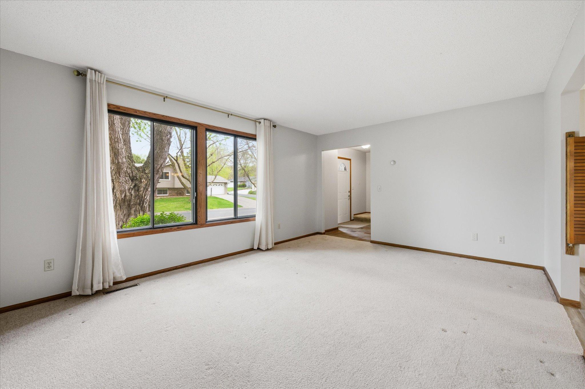 You’ll love how sunlight fills this inviting living room through the large front-facing window while offering peaceful neighborhood views.