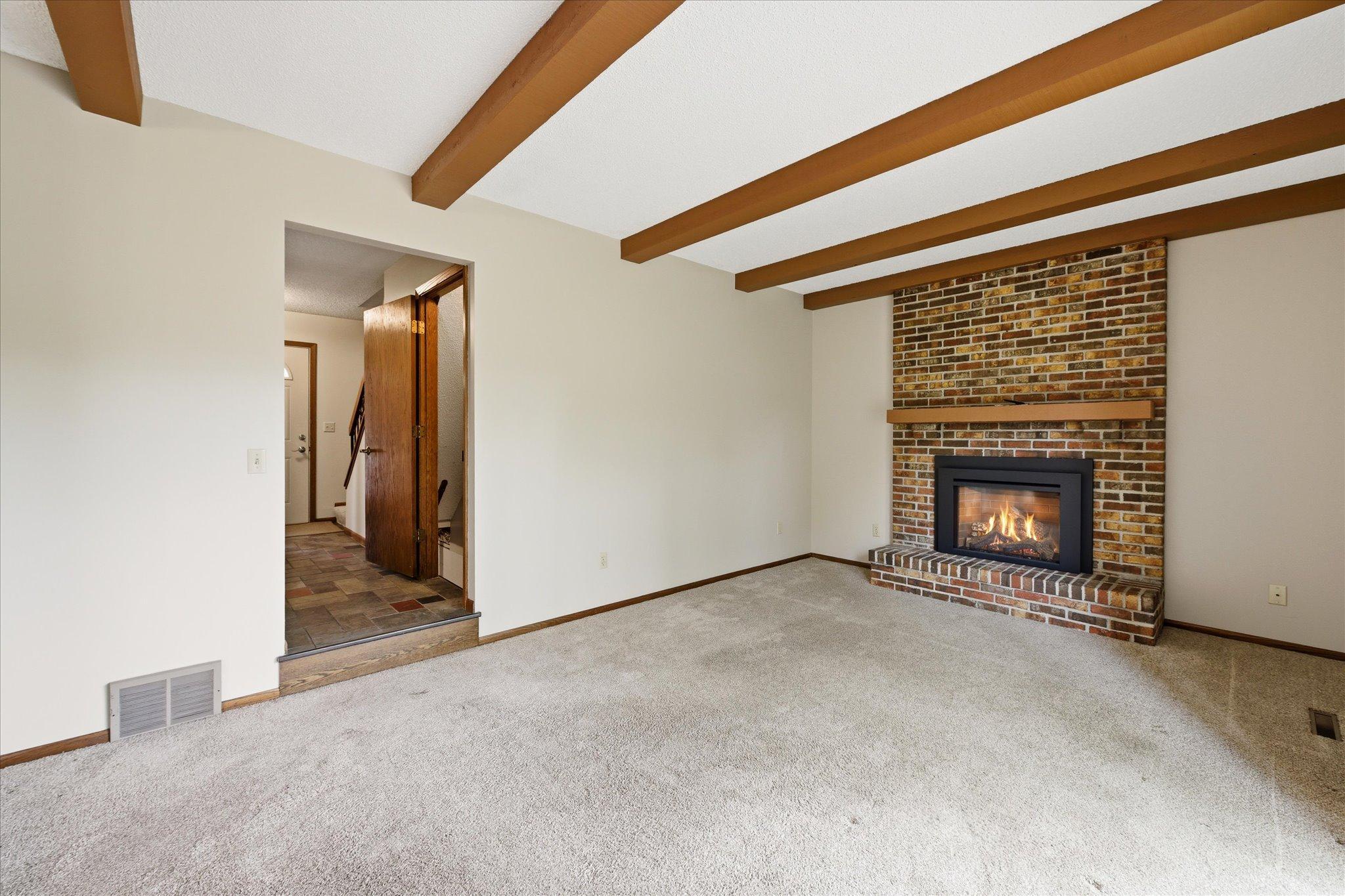 A cozy gas-burning fireplace with classic brick surround becomes the focal point of this comfortable family room.