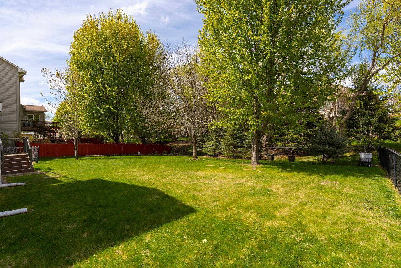Private fenced backyard surrounded by mature trees