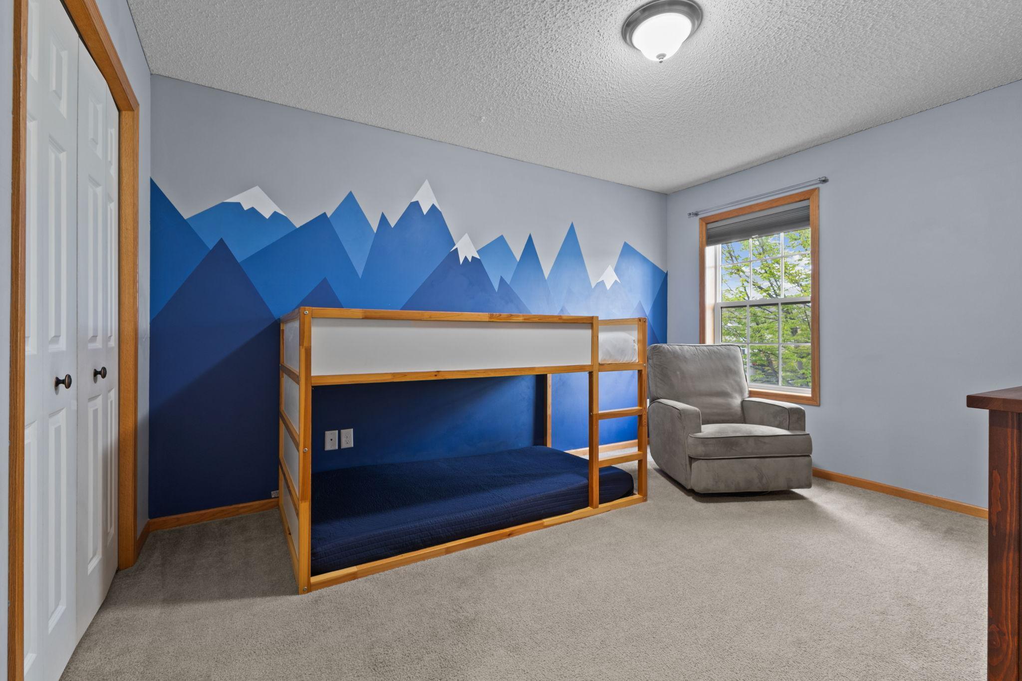 In addition to the primary bedroom, this large west-facing bedroom is also on the same floor. To the right of this photo is a small nook with built-in shelves.