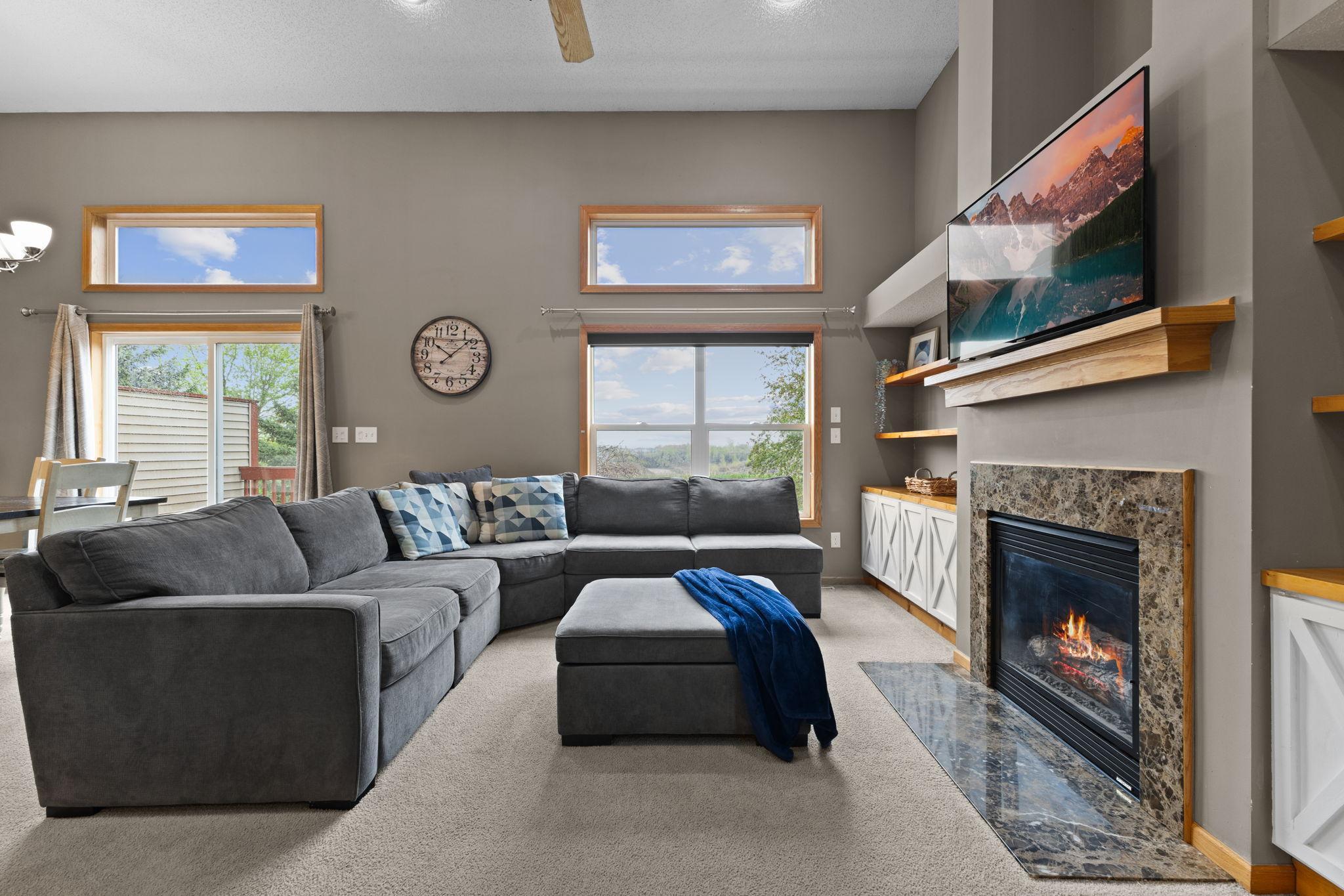 As you are walking up the stairs, this is what you will see to your right. Floor to ceiling windows, built-in cabinets, gas fireplace. To the left of this photo is the dining area and kitchen.
