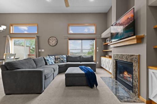 As you are walking up the stairs, this is what you will see to your right. Floor to ceiling windows, built-in cabinets, gas fireplace. To the left of this photo is the dining area and kitchen.