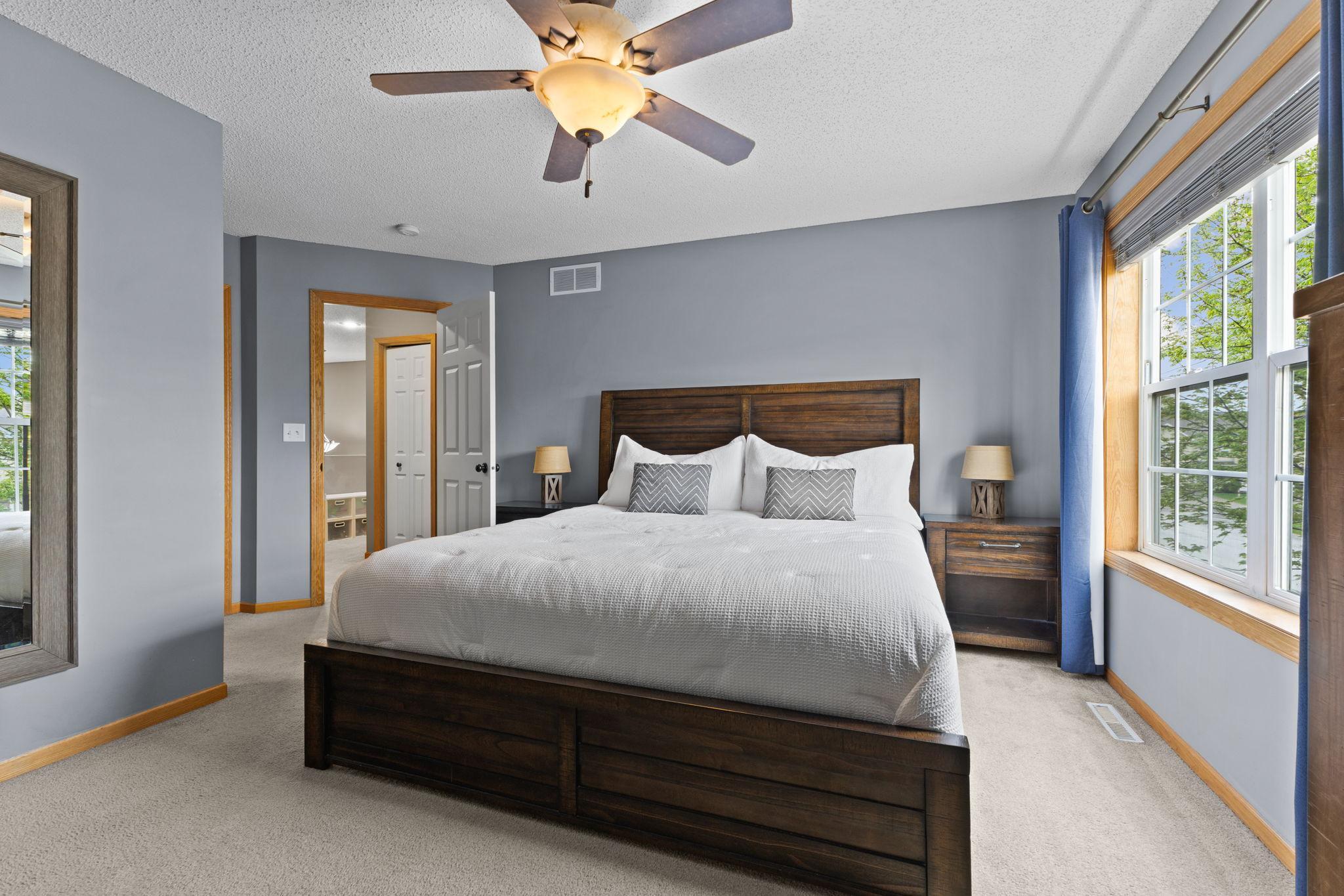 The primary bedroom is west facing with large windows for natural light. There is a walk in closet on the other side of the mirror wall.