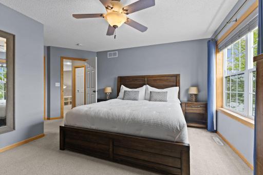 The primary bedroom is west facing with large windows for natural light. There is a walk in closet on the other side of the mirror wall.