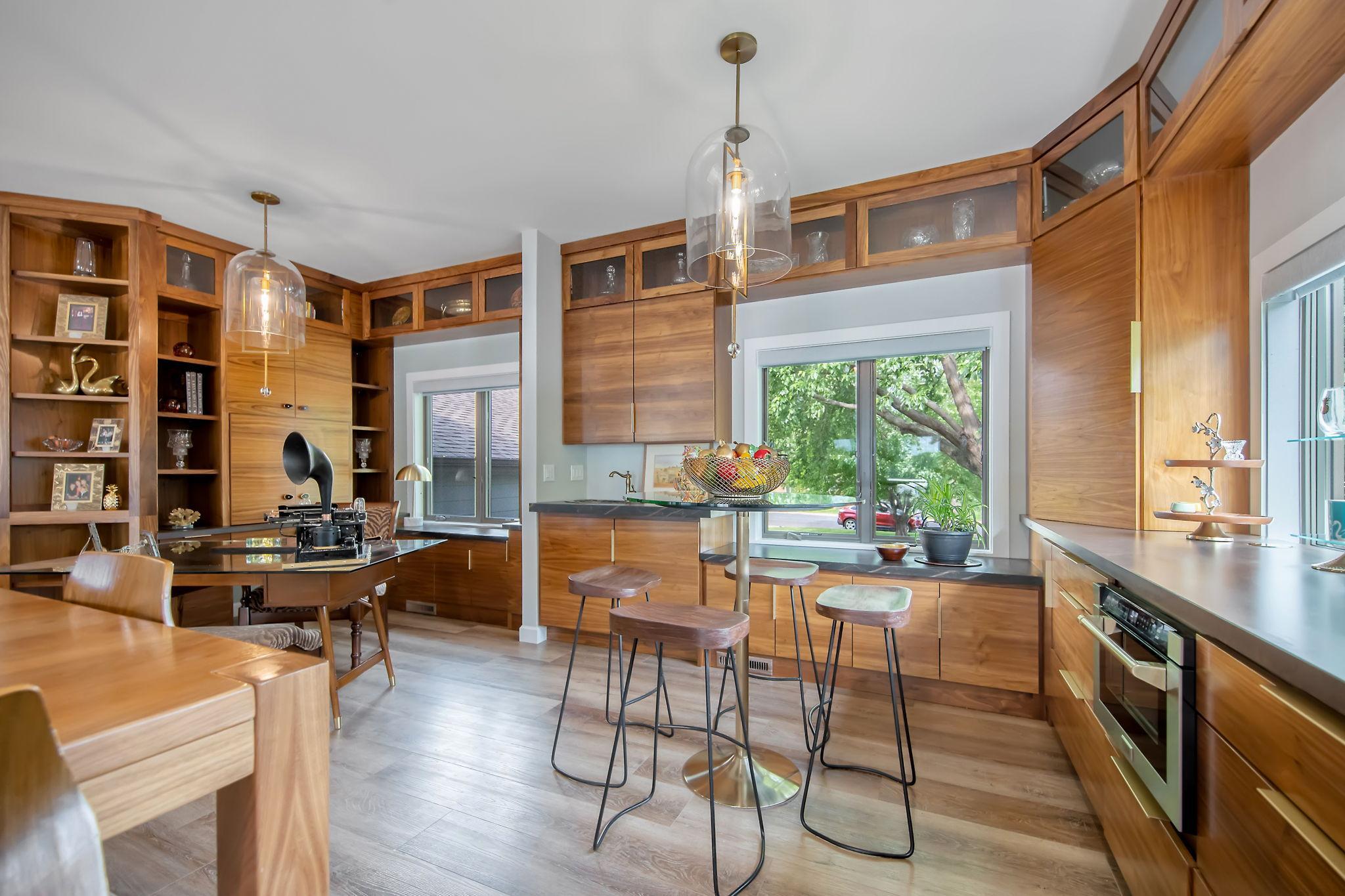 Custom walnut cabinetry wraps around the kitchen, office, wet bar and informal dining room.