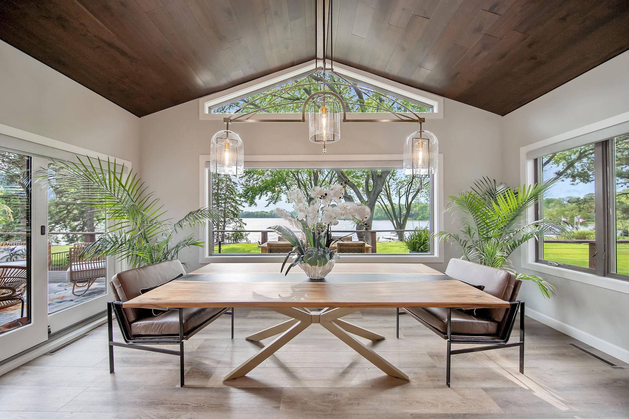 The vaulted formal dining room is surrounded by huge windows offering panoramic views. A restoration Hardware light fixture completes the space.