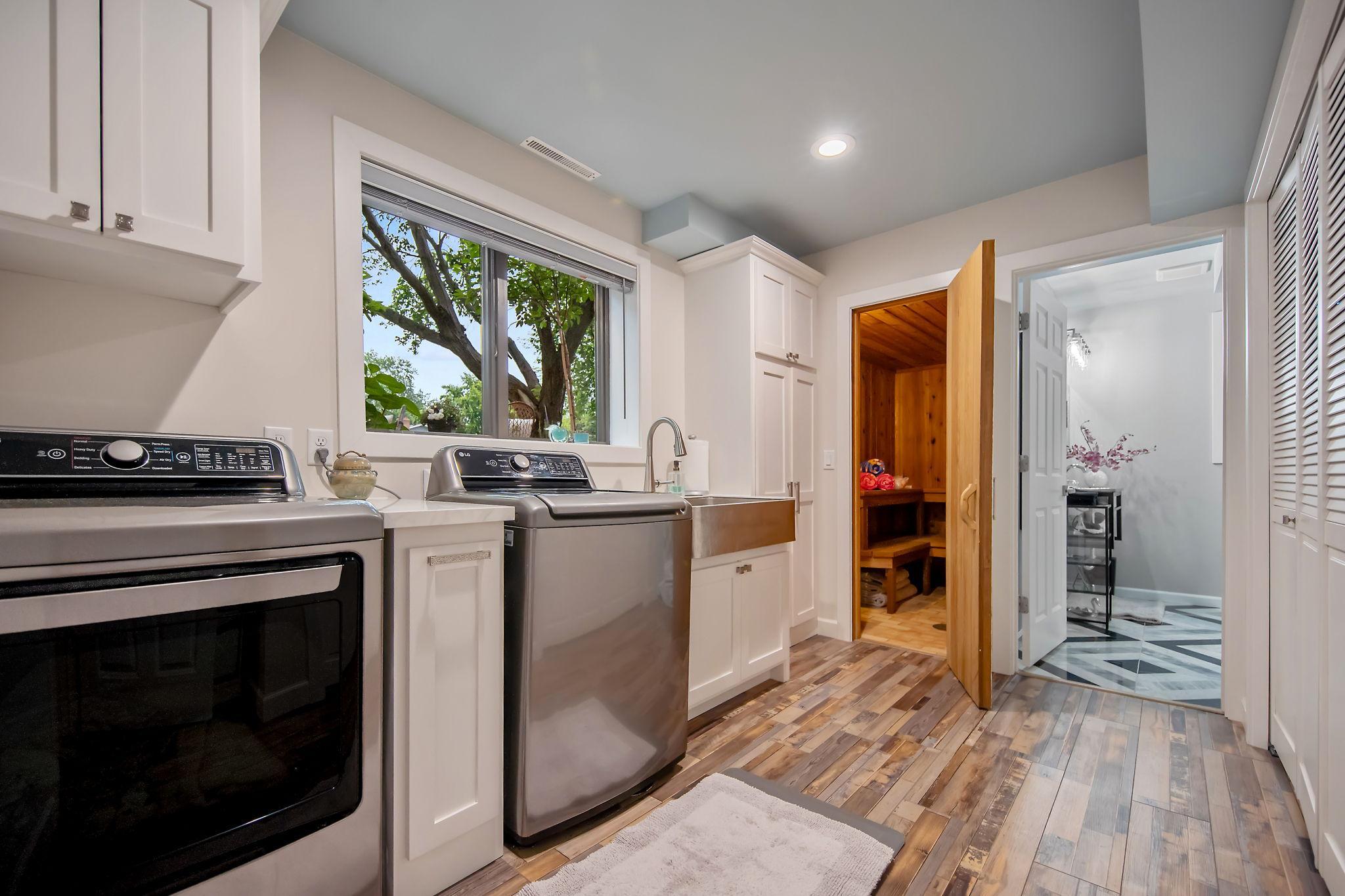 Laundry room is large with pull out central drawer, hammered farmhouse sink and large capacity LG washer and dryer.