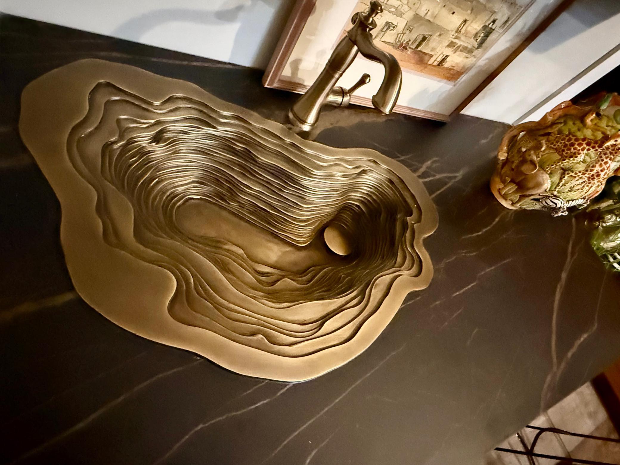 Hand made slaty cast bronze sink surrounded by Italian (Laminam brand) countertops in the upper level bar area.