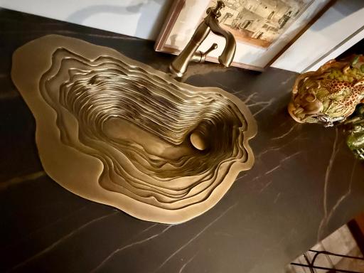 Hand made slaty cast bronze sink surrounded by Italian (Laminam brand) countertops in the upper level bar area.