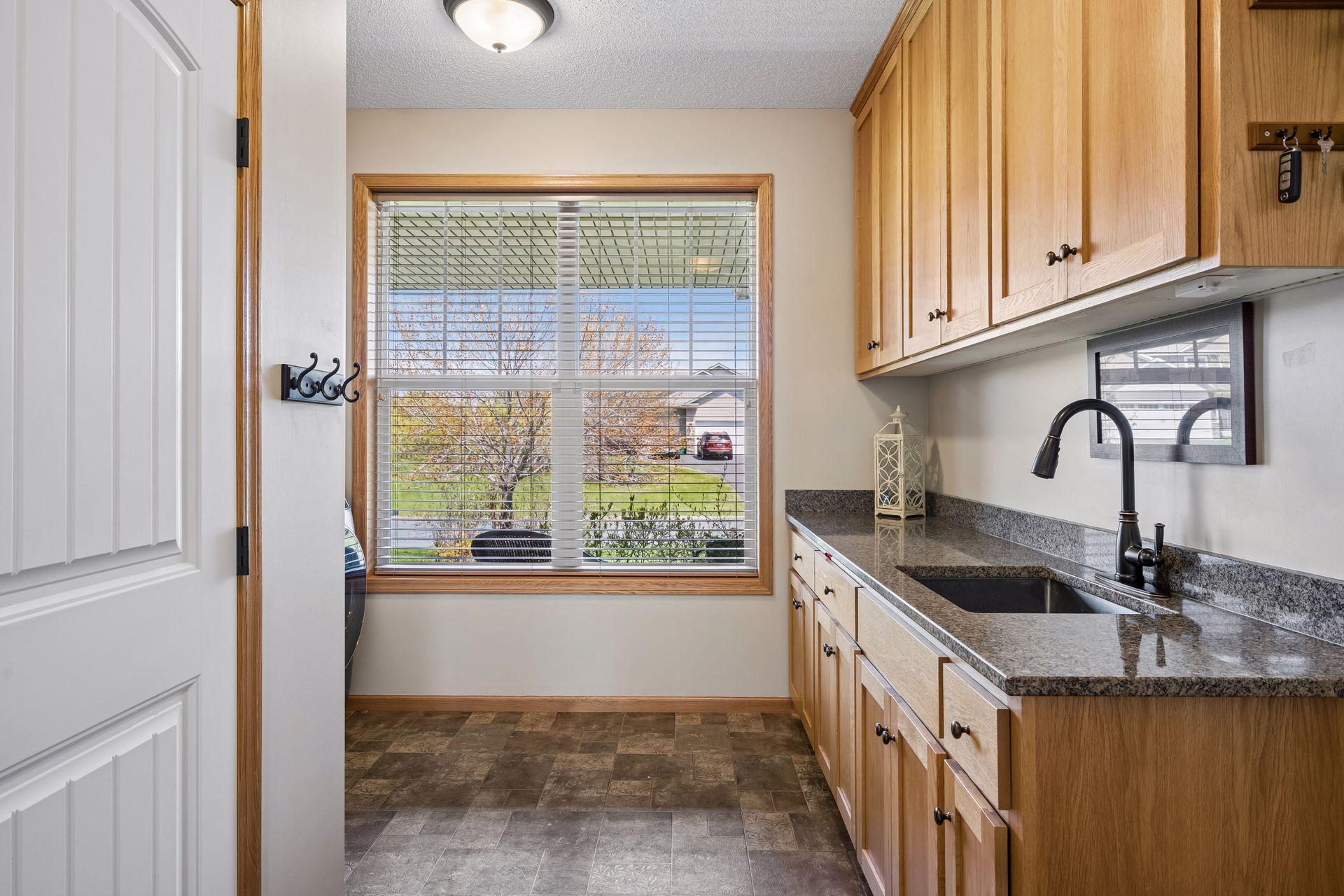 Laundry/mudroom with a convenient granite counter with granite and plenty of cabinets for storage