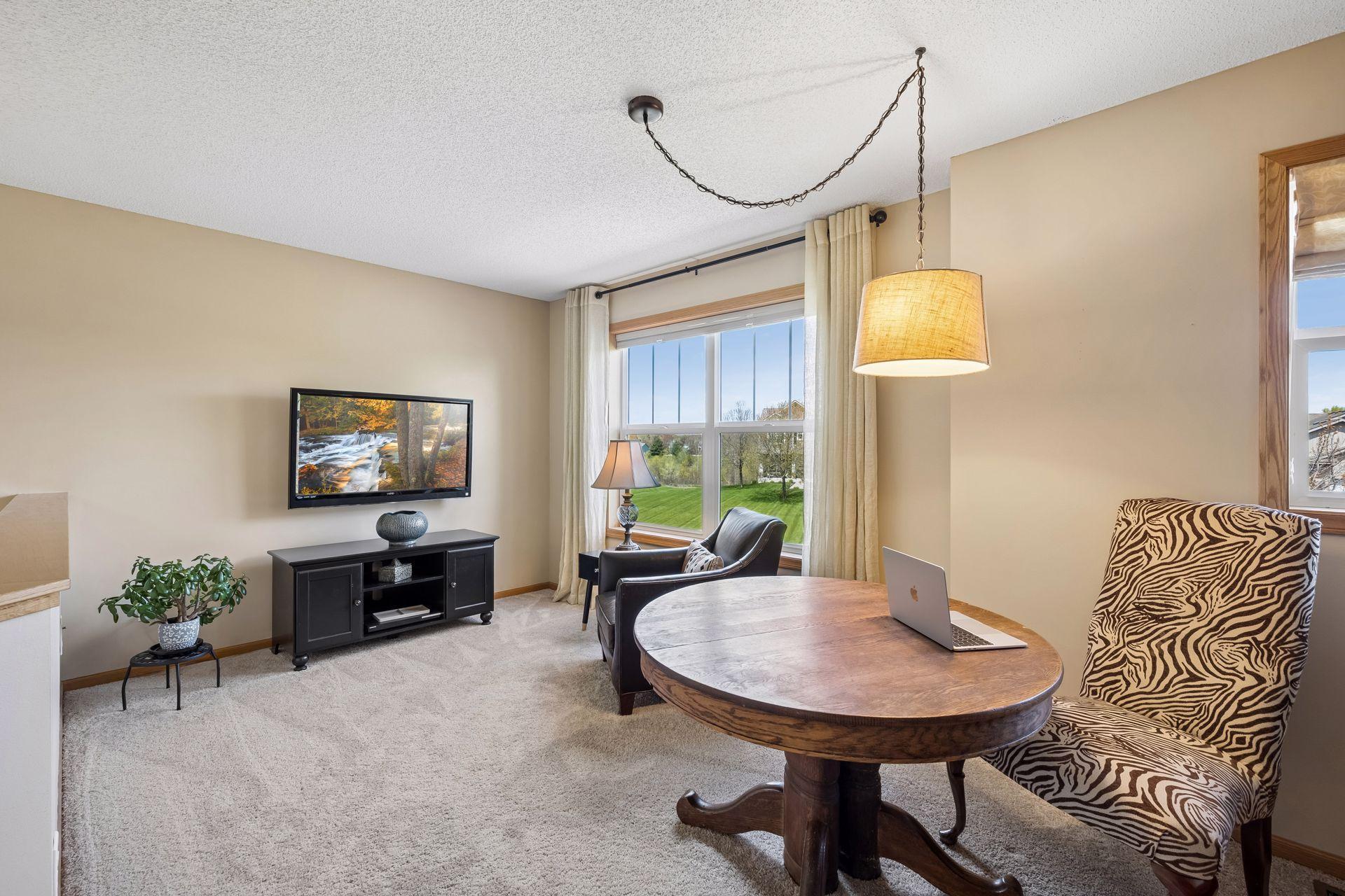 Versatile upper-level loft offers the perfect space for a home office, reading nook, or additional living area. Large windows create a bright and inviting space.