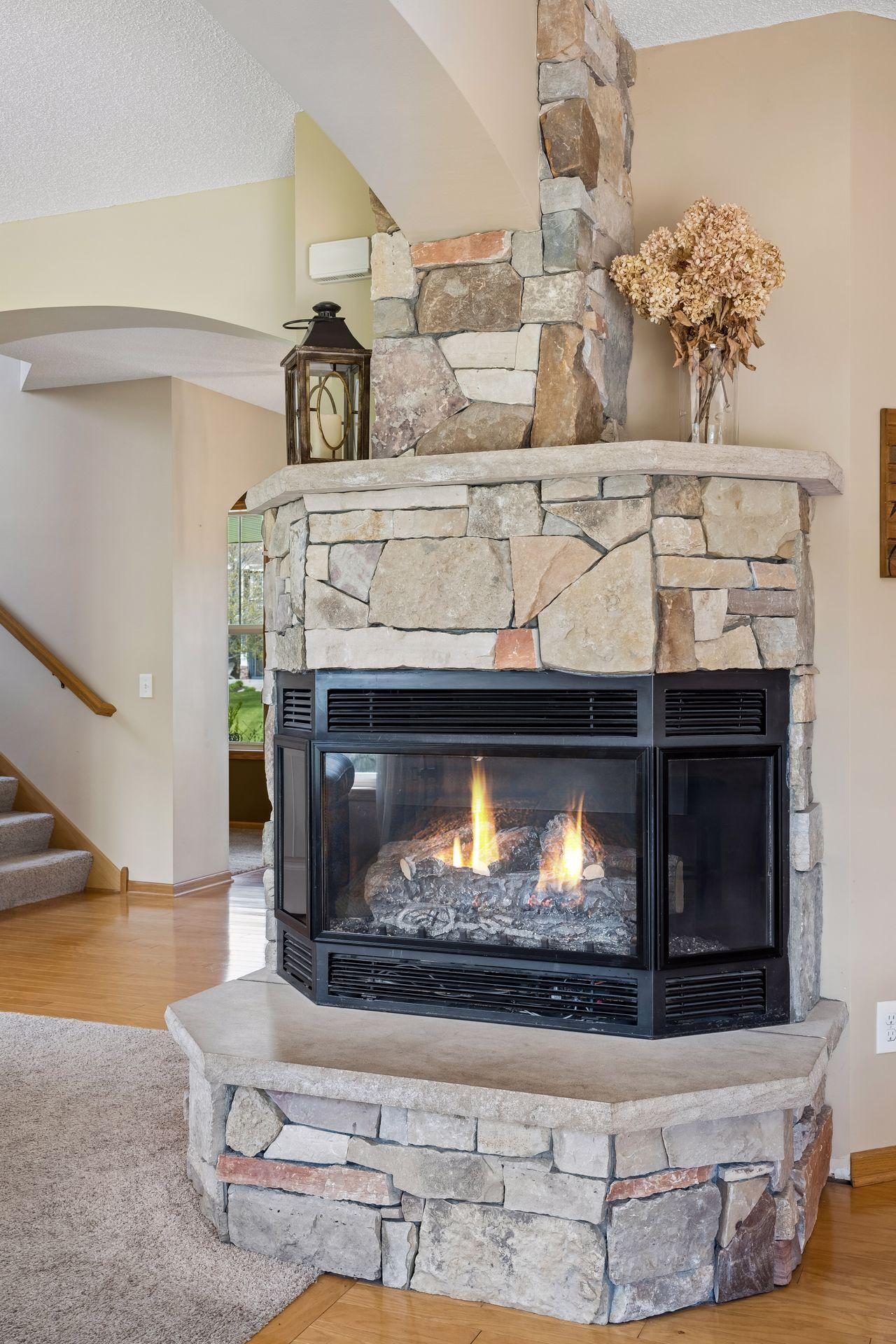 The beautiful floor-to-ceiling stone fireplace creates a warm and inviting focal point - supplemental heat with a furnace-rated fireplace.