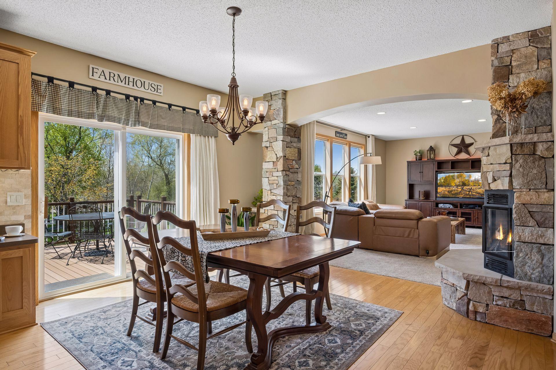 Dining area with a stone fireplace, and convenient access to the deck and backyard.