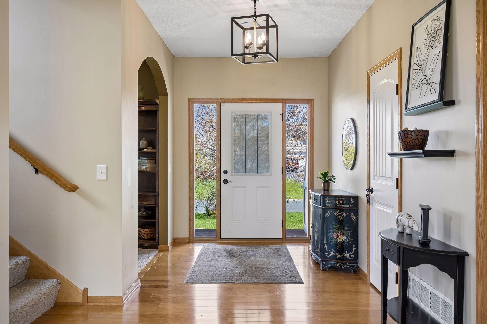 Bright and welcoming foyer with soaring ceilings and warm natural light.