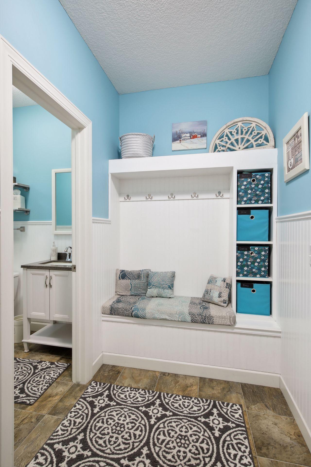 The mudroom off the garage and kitchen has custom lockers as well as a walk-in closet with built-in closet organizers and countertop.