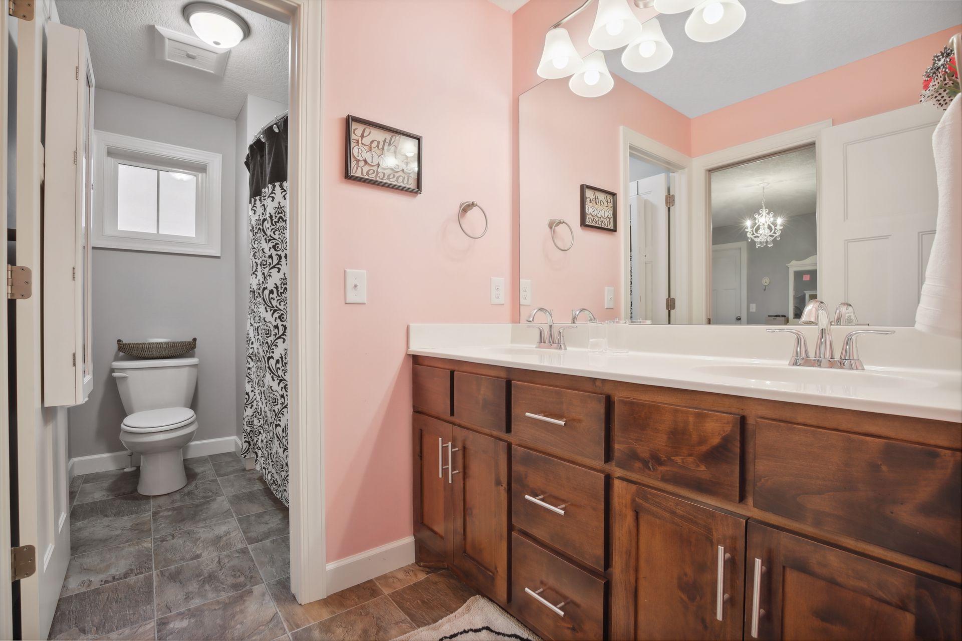The Jack and Jill bath has double vanity and a separate room for stool and shower.