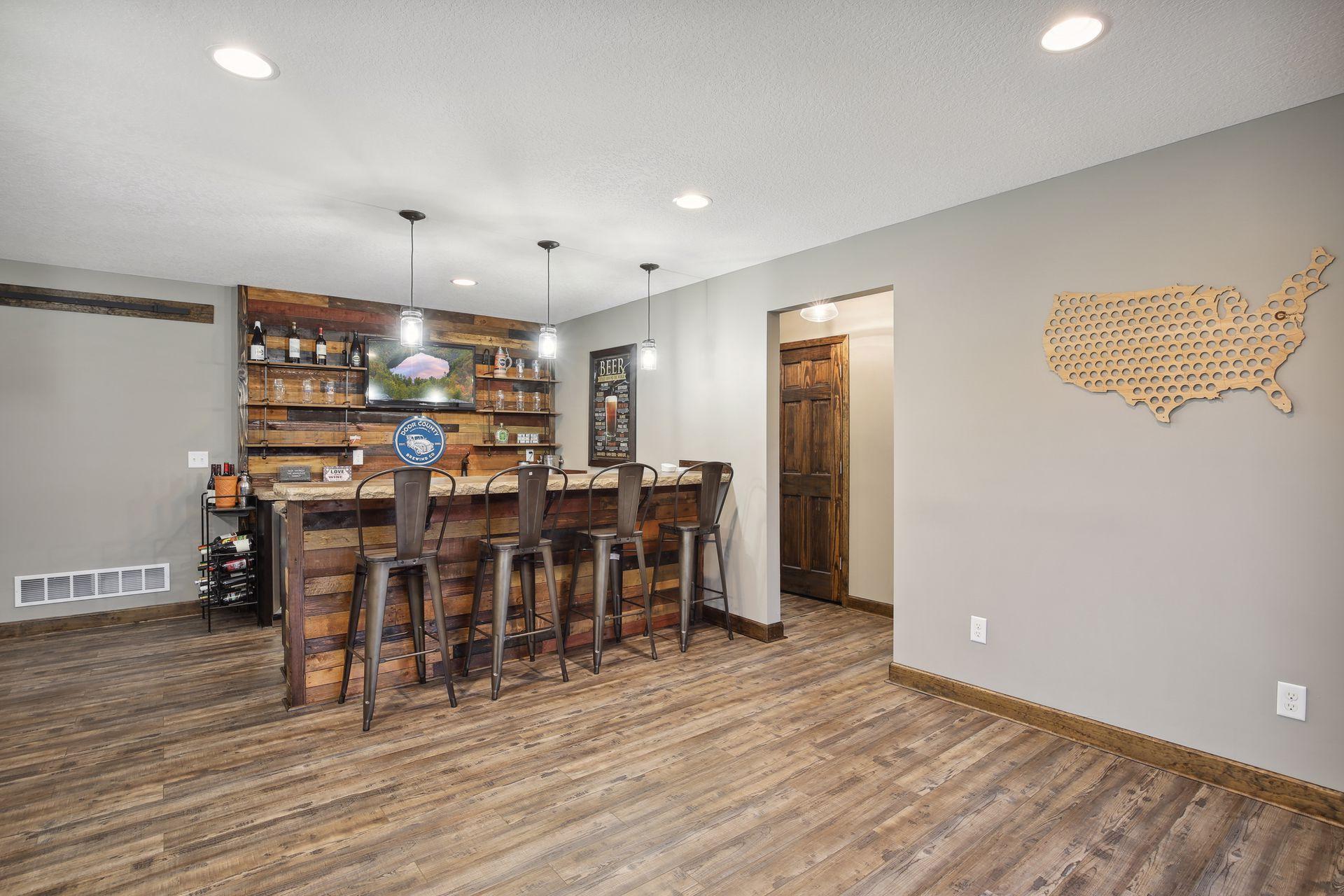 The rustic full service wet bar is sure to please with open shelving, sink and fridge.