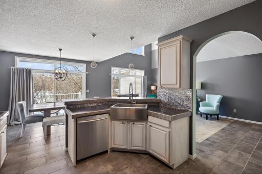 Updated kitchen features stainless steel appliances, a breakfast bar, and seamless flow to the dining area.