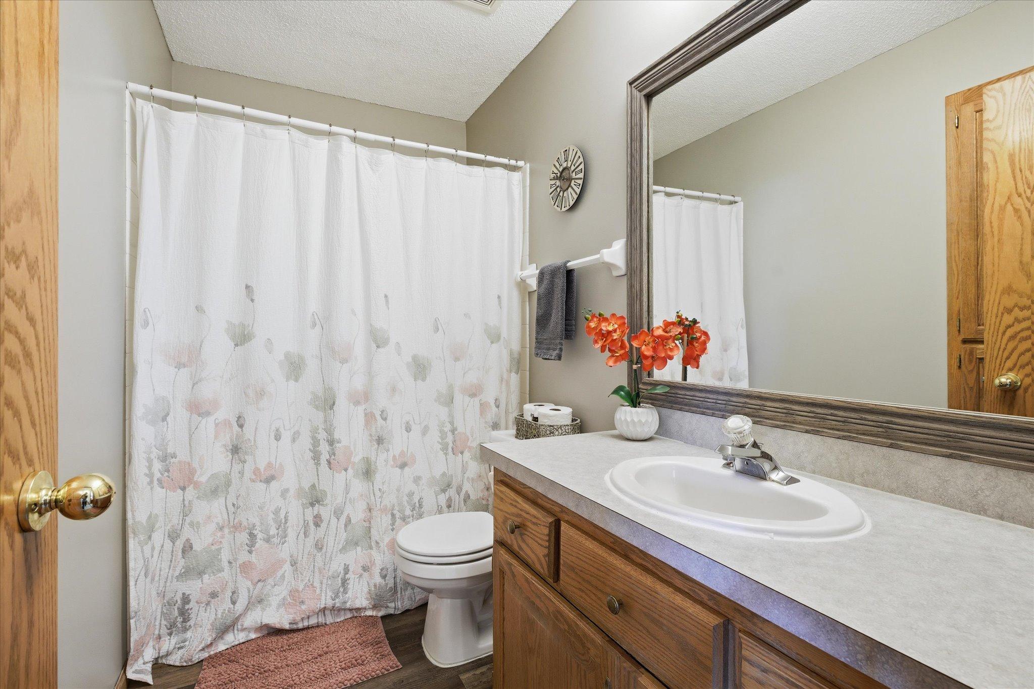 The other upper level bathroom is a full bath with a tub/shower surround, upgraded flooring and a custom-framed mirror.
