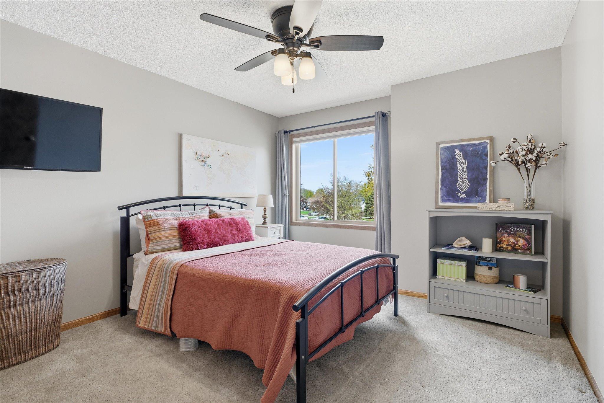Upper level bedroom #2 has modern & neutral carpet & paint, a new window from 2022, top-end window treatments and an included TV mount.