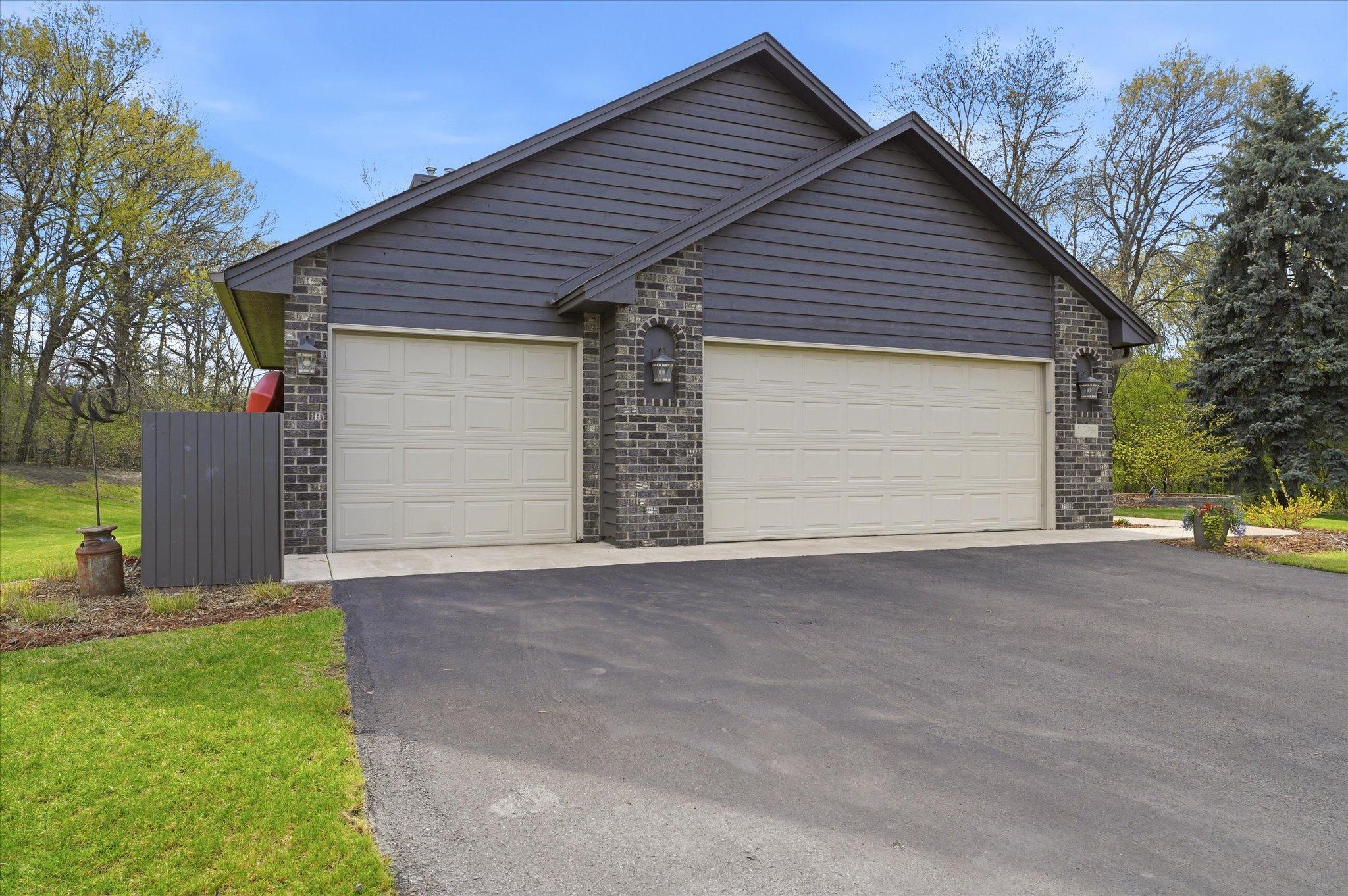 There is even a fenced in trash & recycling can storage area. The brick accents and address stone add to the stately curb appeal.