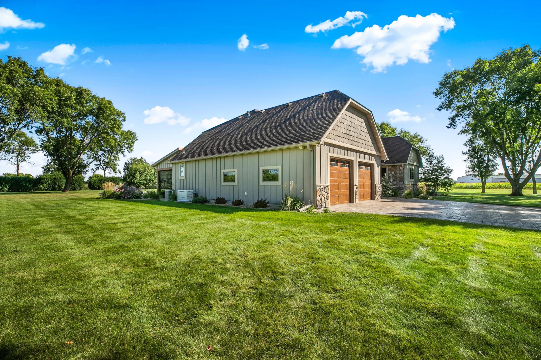 The attached garage is fully finished and heated with epoxy floors, floor drain, hot/cold water access, built-in speakers, and quiet side-mounted openers for the overhead garage doors.