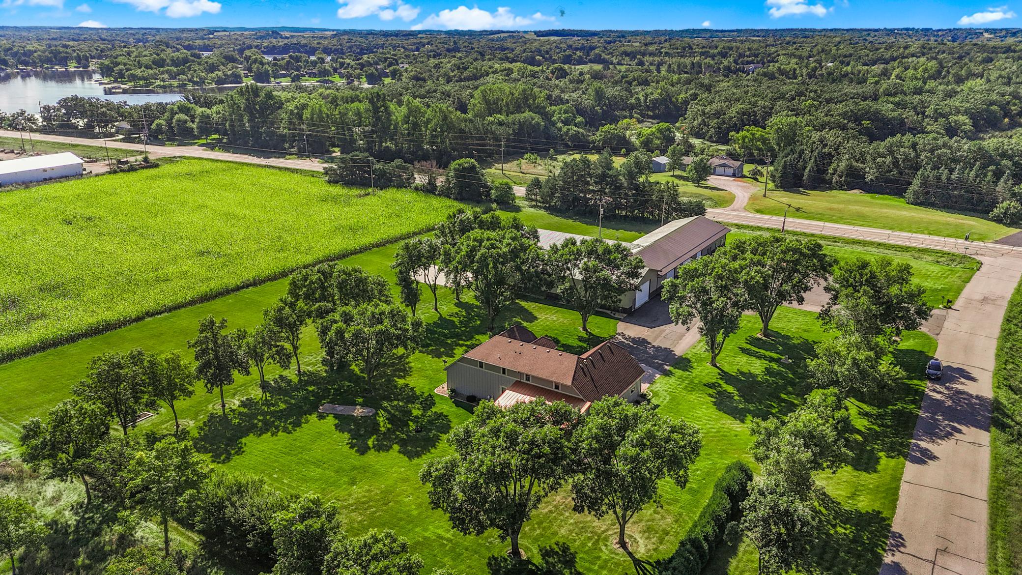 The outbuilding includes finished office space with in-floor heat, forced air heat and central A/C, a kitchen, two 1/2 bathrooms, and multiple overhead doors.