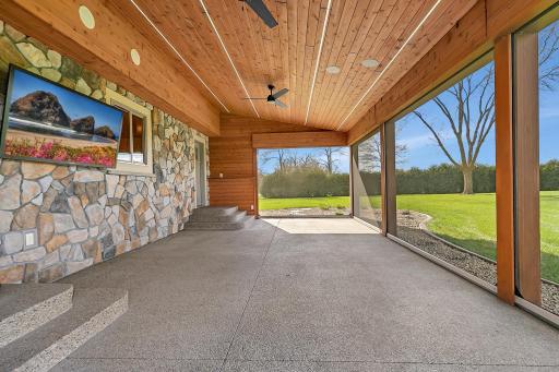 It features motorized retractable screens, built-in speakers, and ceiling fans.