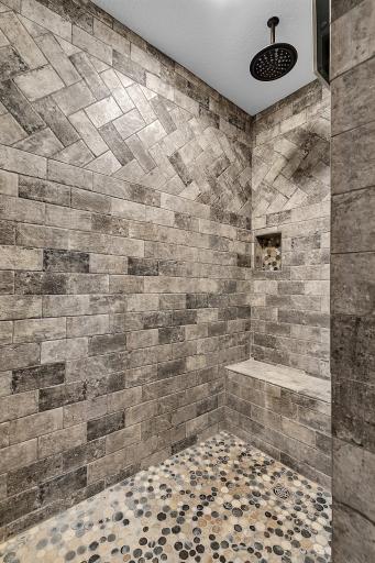 A spa-like shower with a rainfall shower head and a built-in bench.