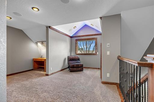 Upstairs, a vaulted bonus area offers a quiet place to unwind, read, or study, complemented by built-in speakers and refined detailing.