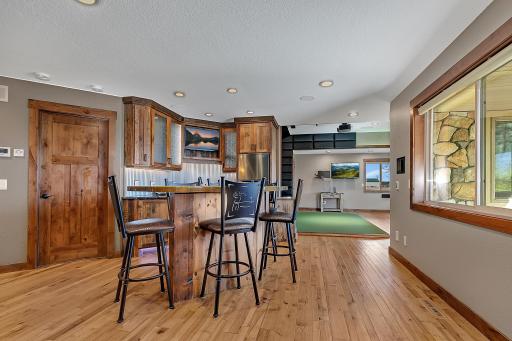 Wet bar with granite countertops and a unique golf-themed island, perfect for entertaining.
