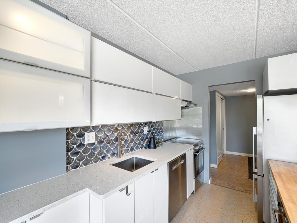 10 - Streamlined kitchen with charming custom tile, plentiful cabinets and butcher block island.