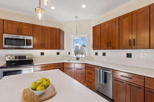 Open kitchen with center island, brand new countertops and backsplash.