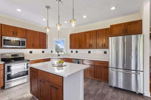 Open kitchen with center island, brand new countertops and backsplash.
