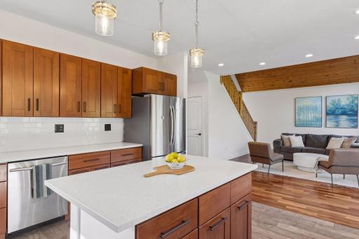 Open kitchen with center island, brand new countertops and backsplash.
