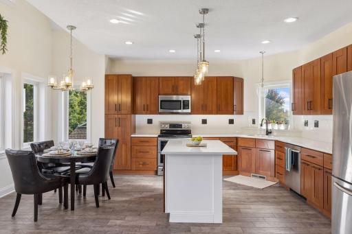 Open kitchen with center island, brand new countertops and backsplash.