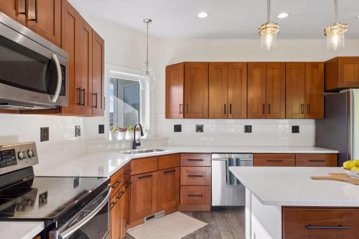 Open kitchen with center island, brand new countertops and backsplash.