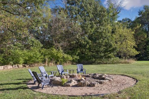 Oversized backyard with firepit, bordering the woods for added privacy.