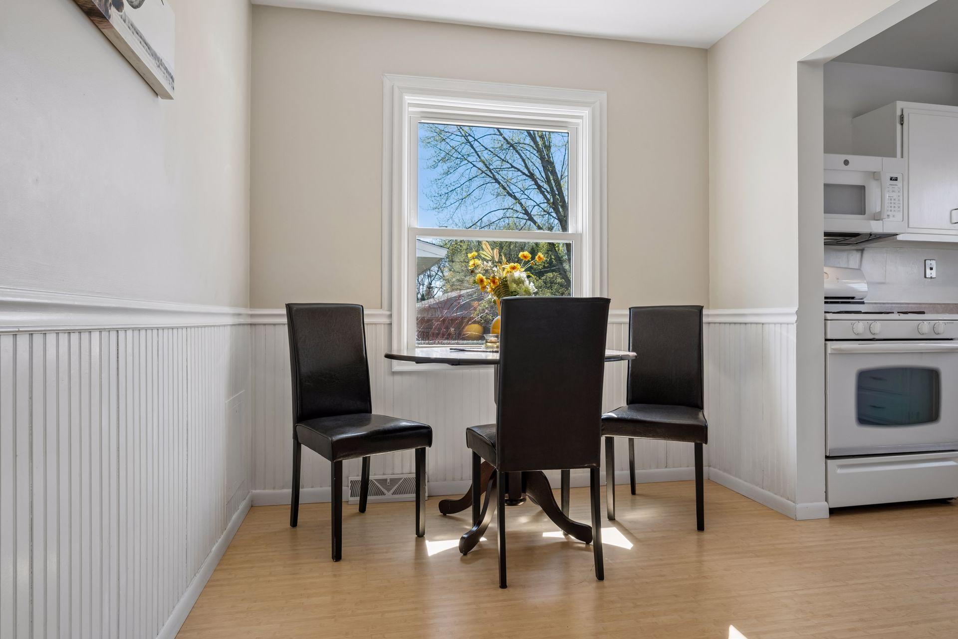 A charming dining space with window overlooking the back patio! A future consideration would be to install a full sliding door for a cohesive connection to the outdoor space.