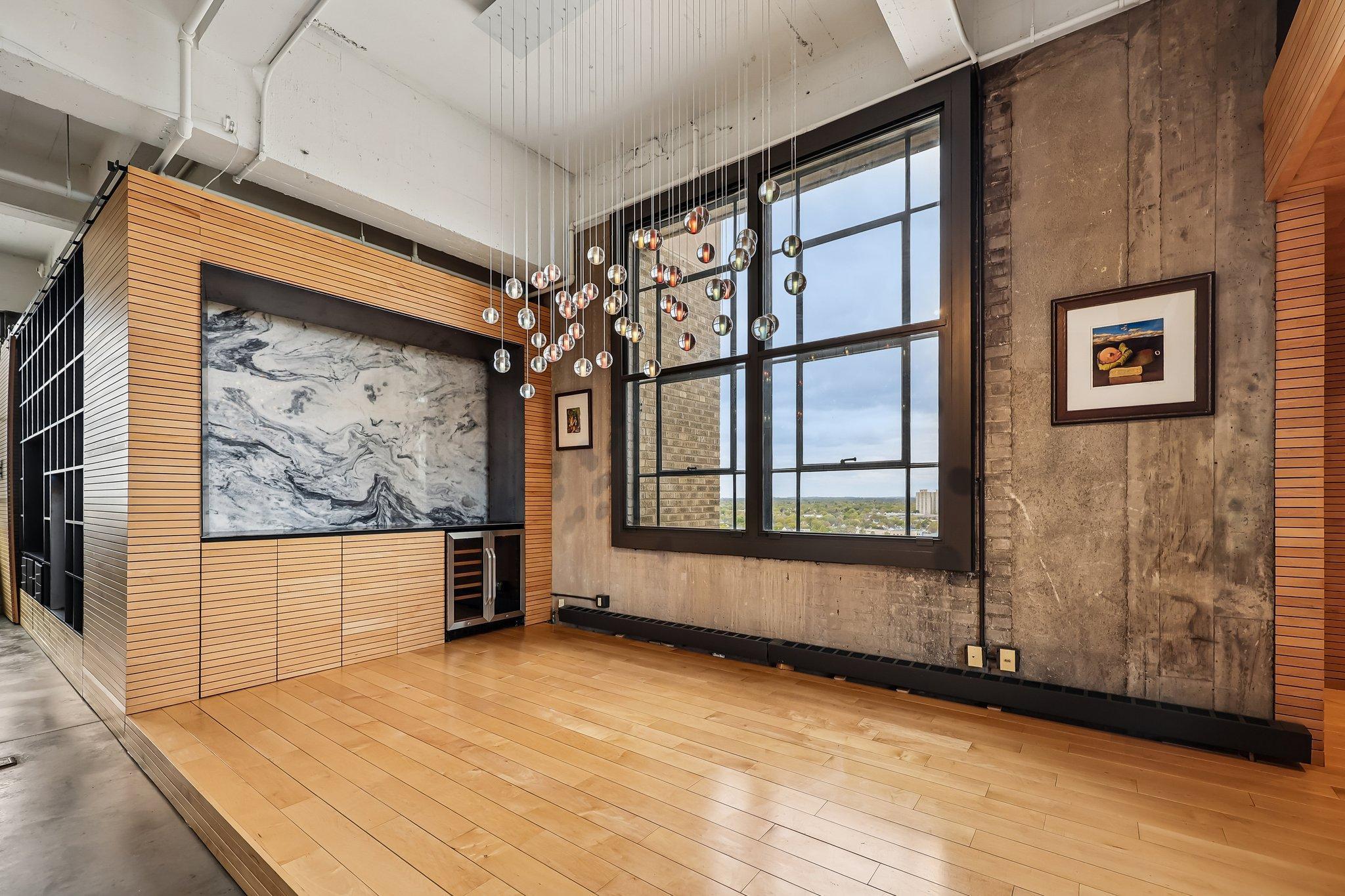 Dining area with wine fridge, entertainment bar with quartz slab, hardwood flooring and fantastic customizable lighting.