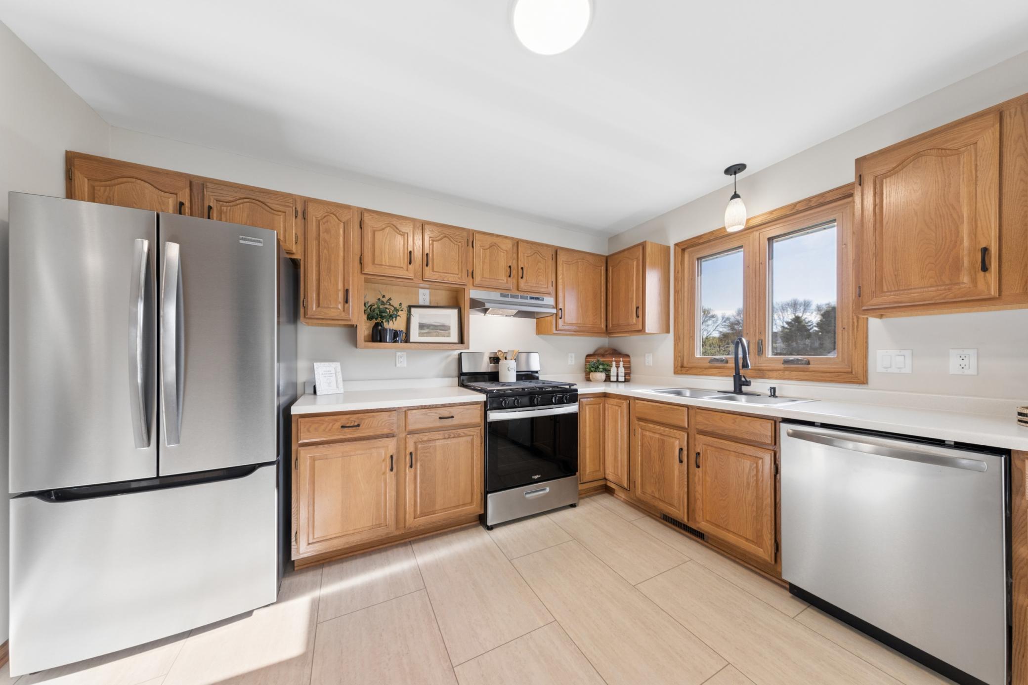 Chef-ready kitchen equipped with brand-new stainless steel appliances, including a 5-burner gas range and French door refrigerator.