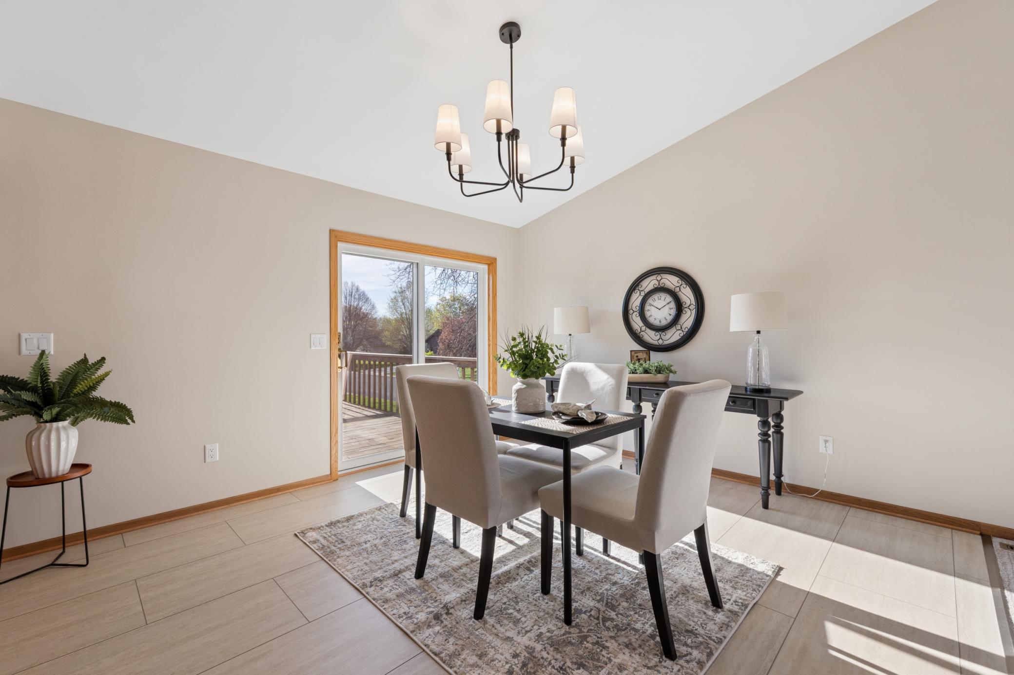 Bright dining area showcasing new LVT flooring, updated light fixtures, and easy walkout access to the deck.